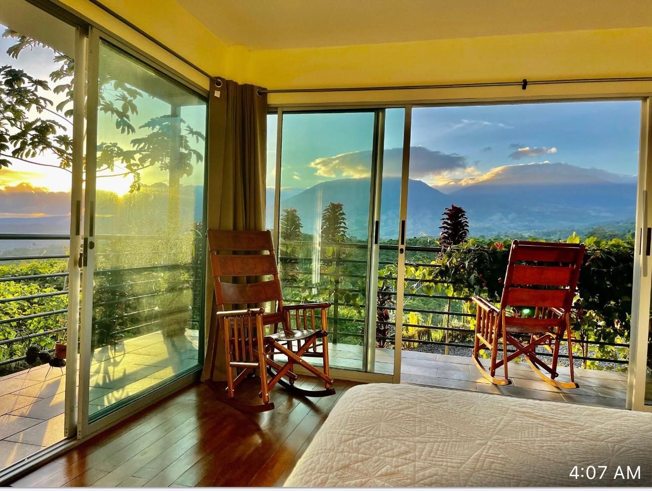 A bedroom with two rocking chairs and a sliding glass door