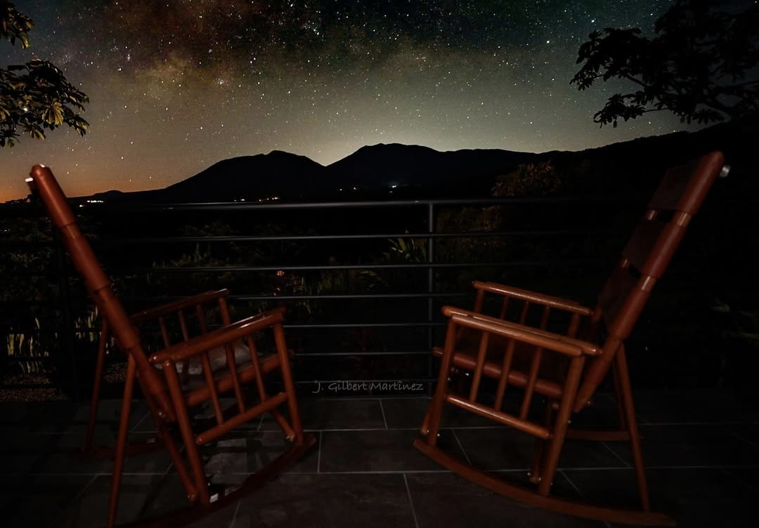 woman in a yoga pose on a balcony overlooking the Costa Rican jungle landscape