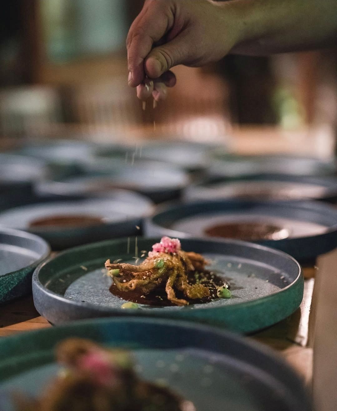 A person is swimming in a pool of blue water surrounded by rocks