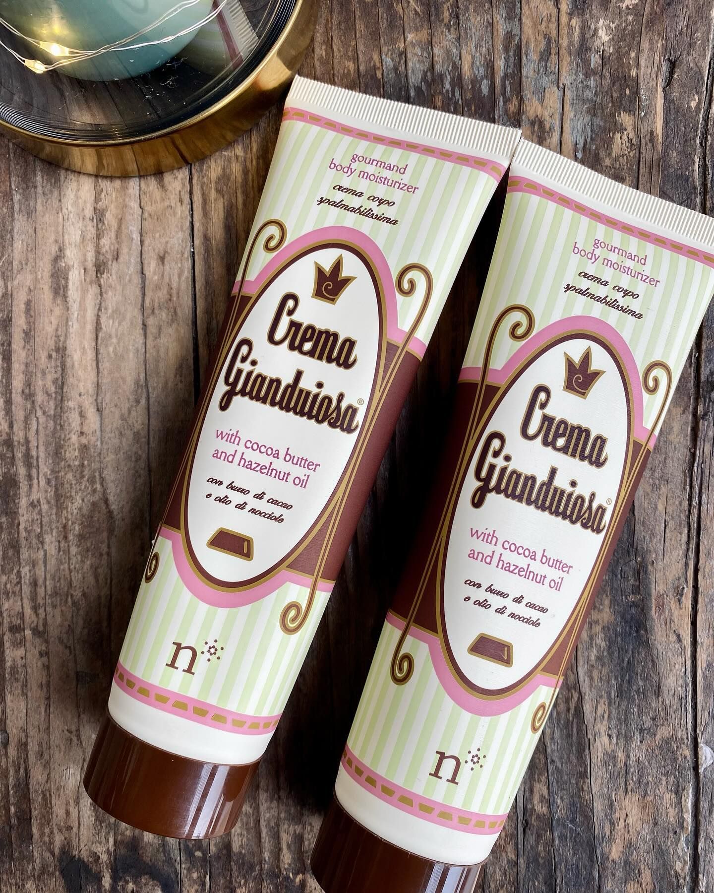 Due tubi di crema sono seduti su un tavolo di legno.