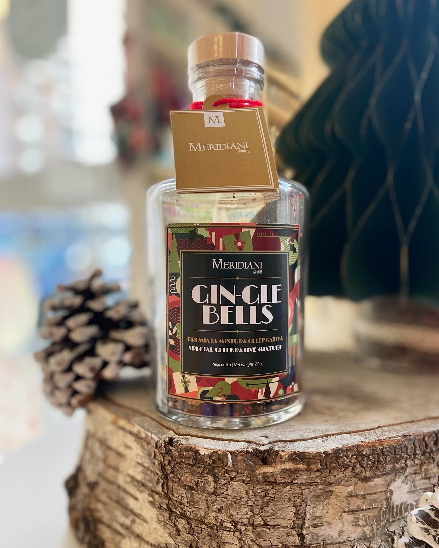 Una bottiglia di gin è posata sopra un ceppo di legno.