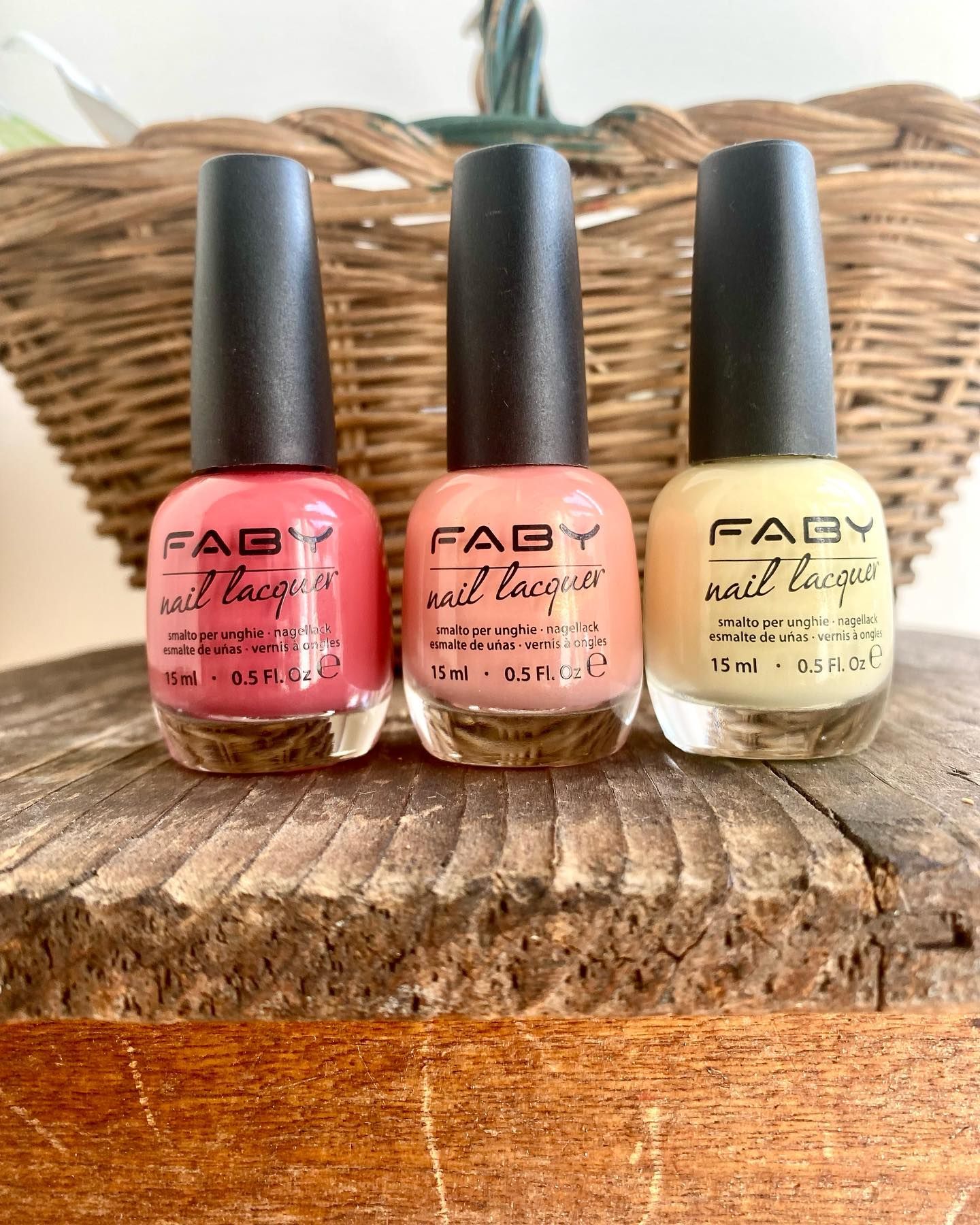 Tre bottiglie di smalto sono sedute su un tavolo di legno.