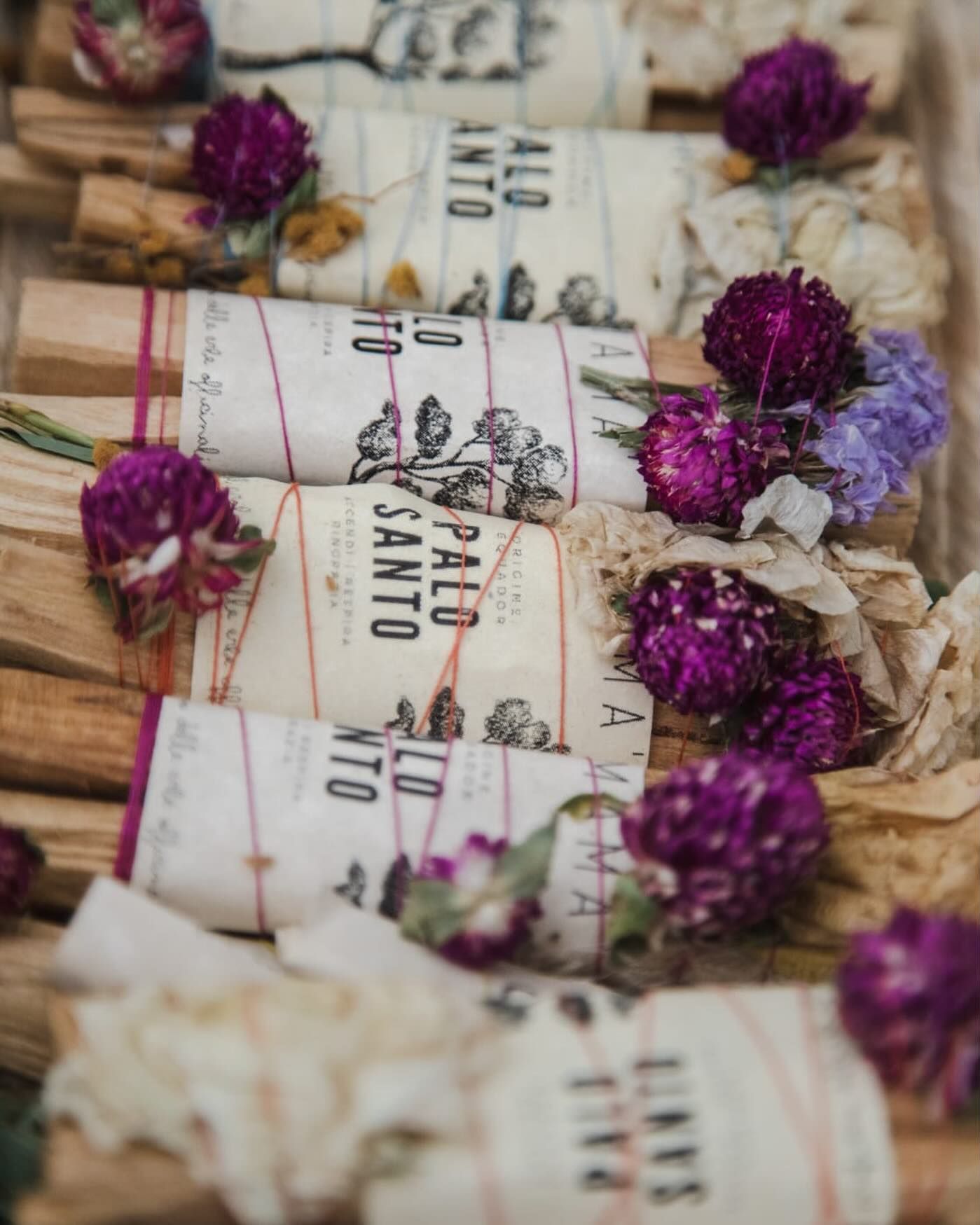 Una fila di bastoncini di palo santo con fiori viola su di essi