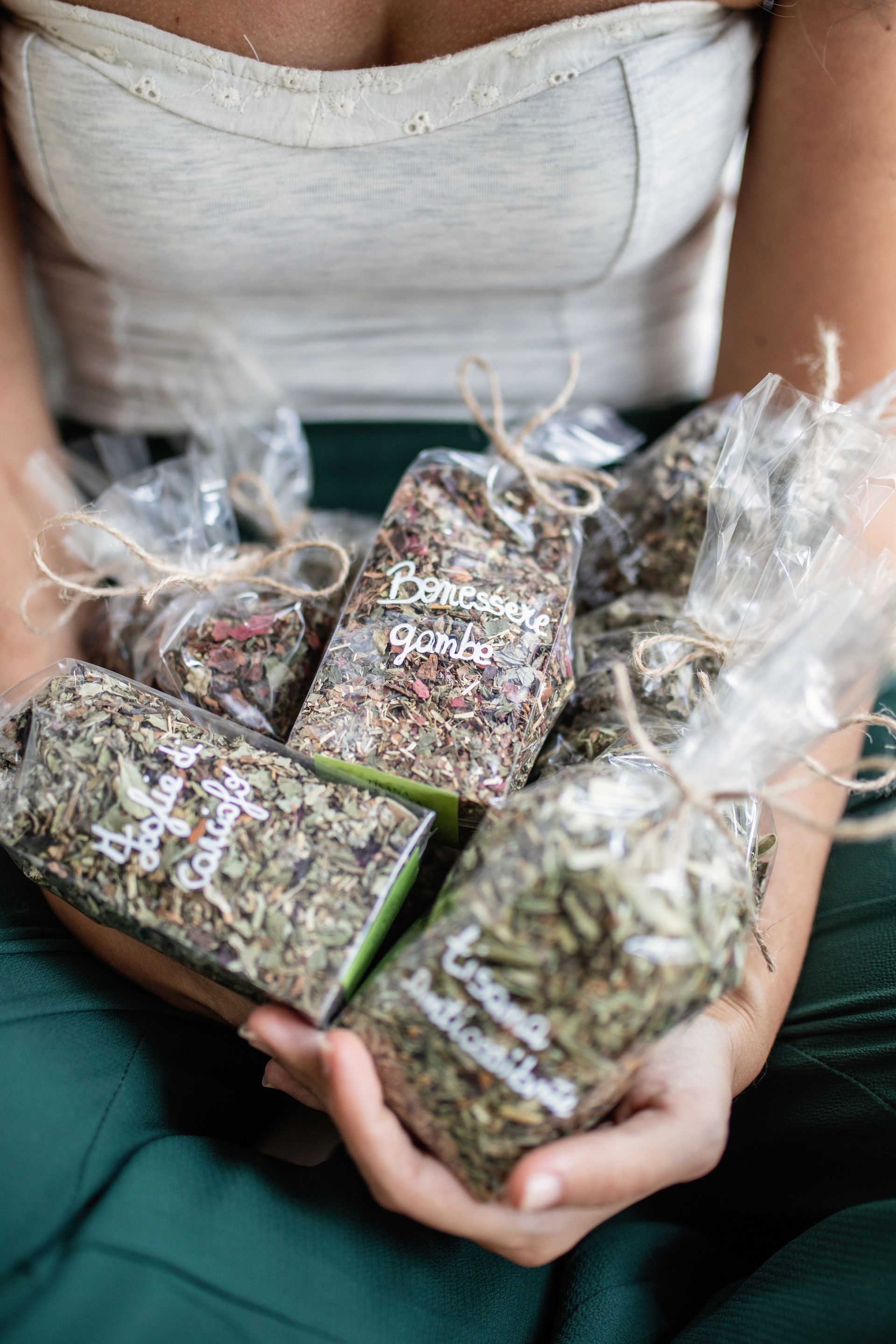 Una donna tiene tra le mani sacchetti di erbe essiccate.