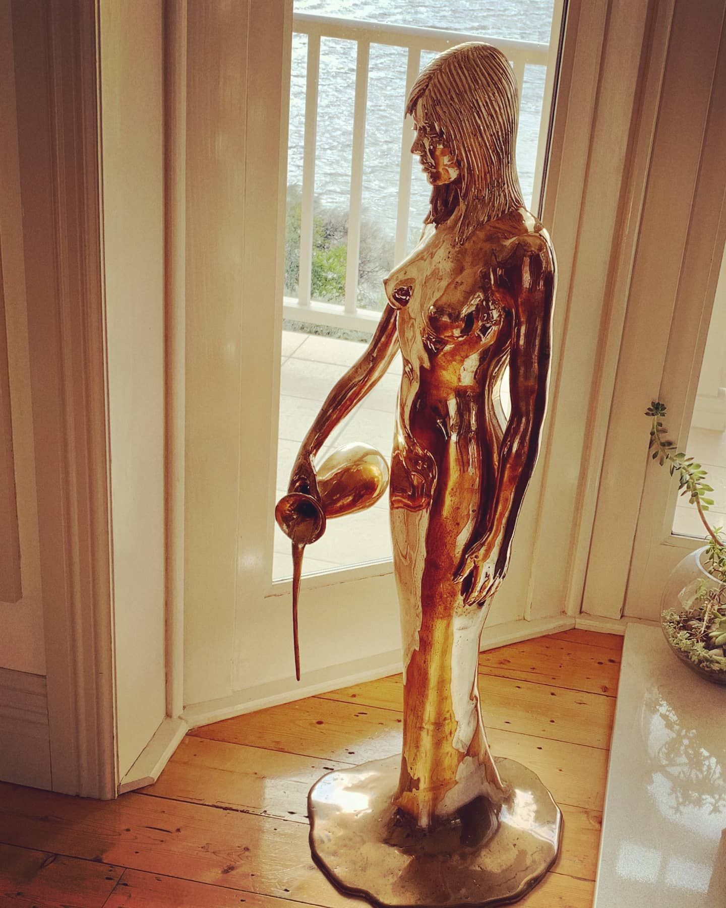 A statue of a woman standing in front of a window