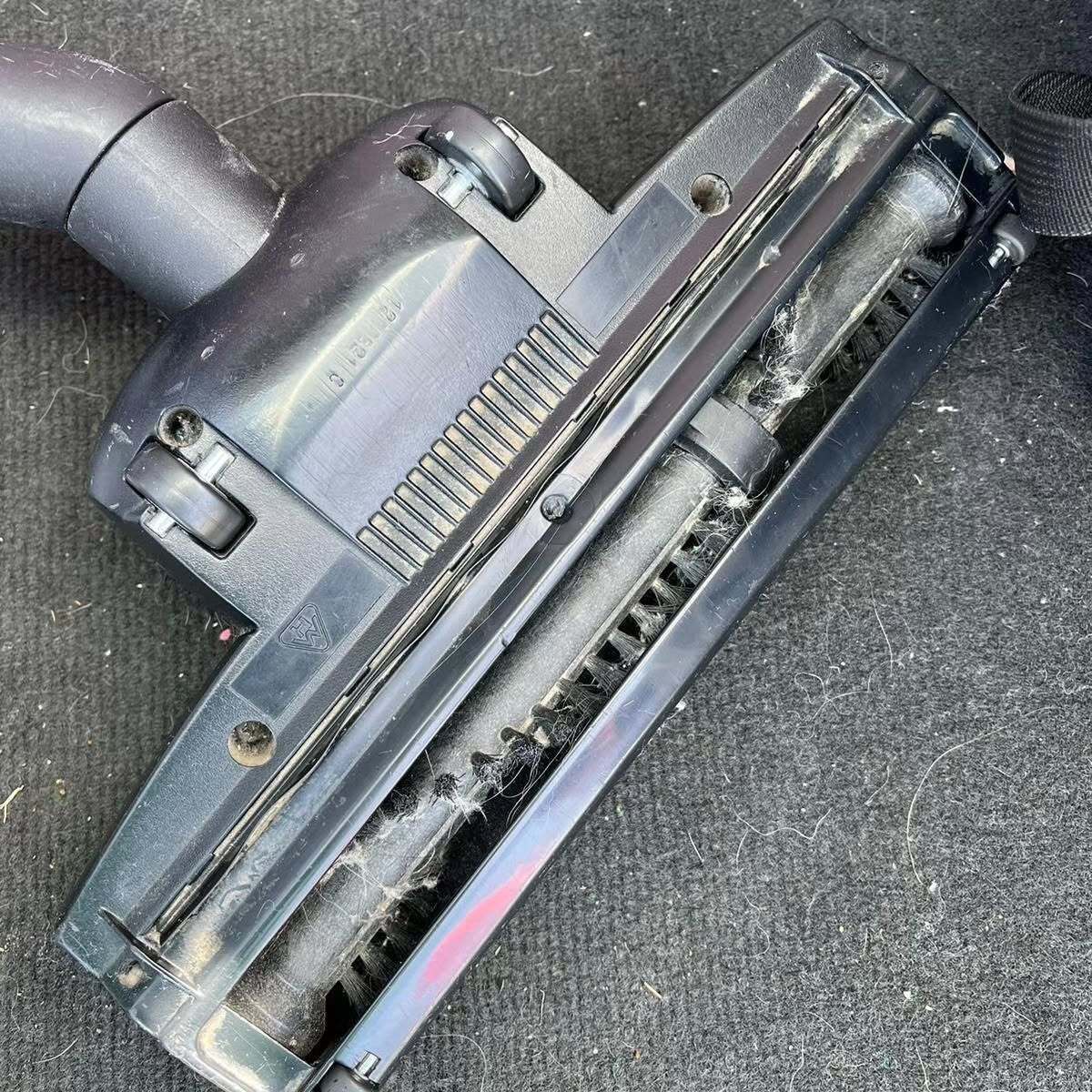 A close up of a vacuum cleaner brush on a black surface.