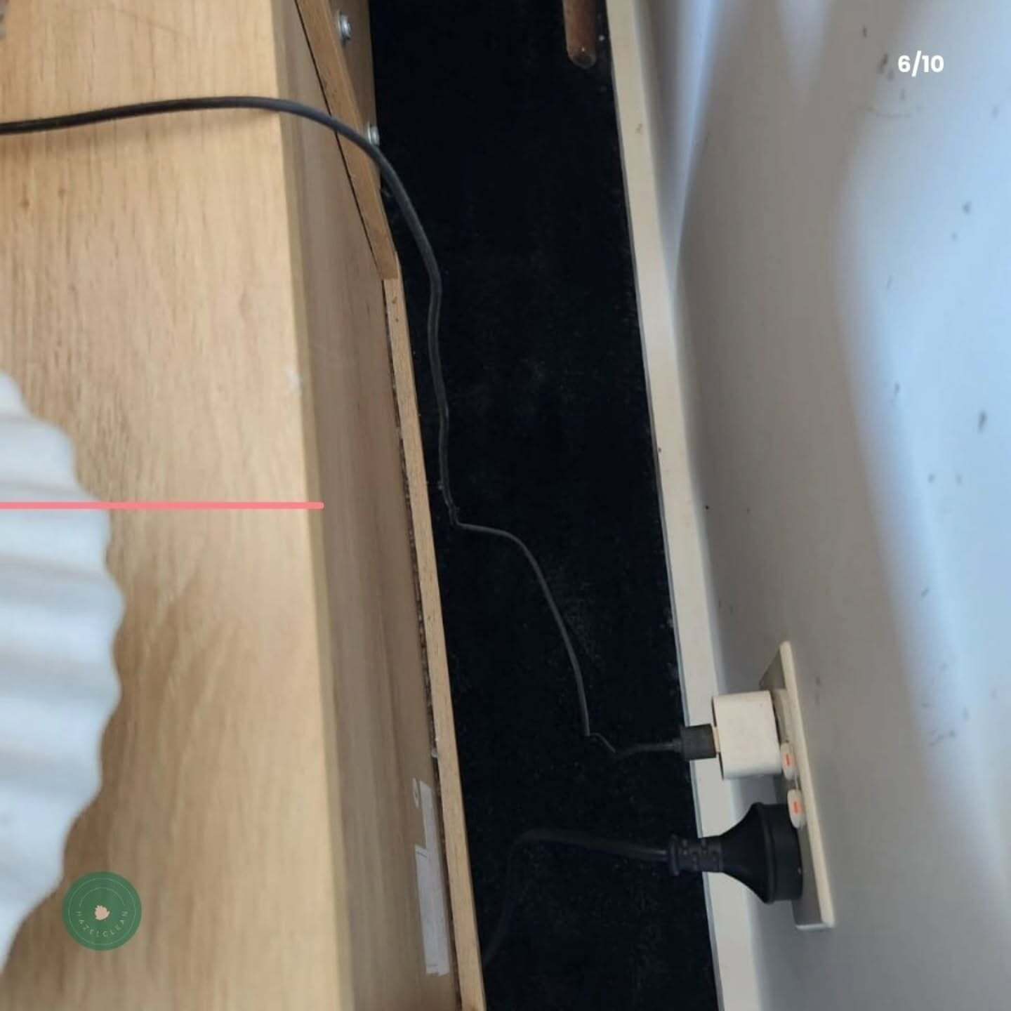 A cord is plugged into a socket on a wooden table