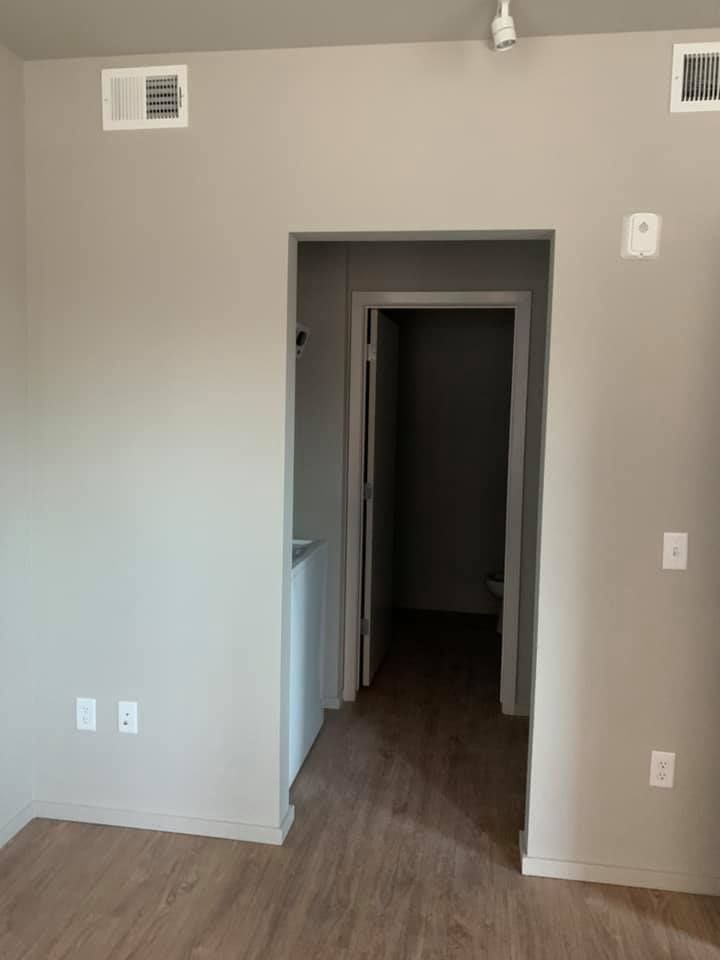 An empty room with a doorway leading to a hallway