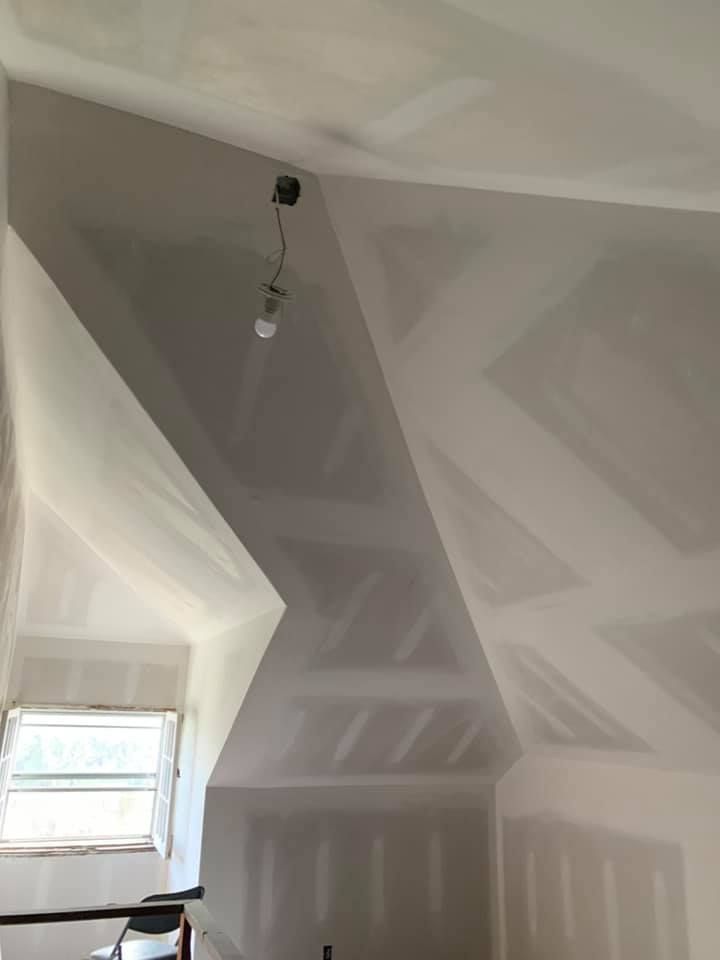 A room with a vaulted ceiling and a light bulb hanging from the ceiling.