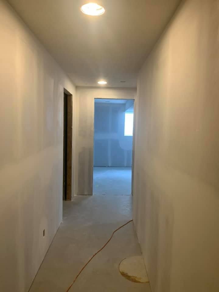 A long hallway with white walls and a light on the ceiling.