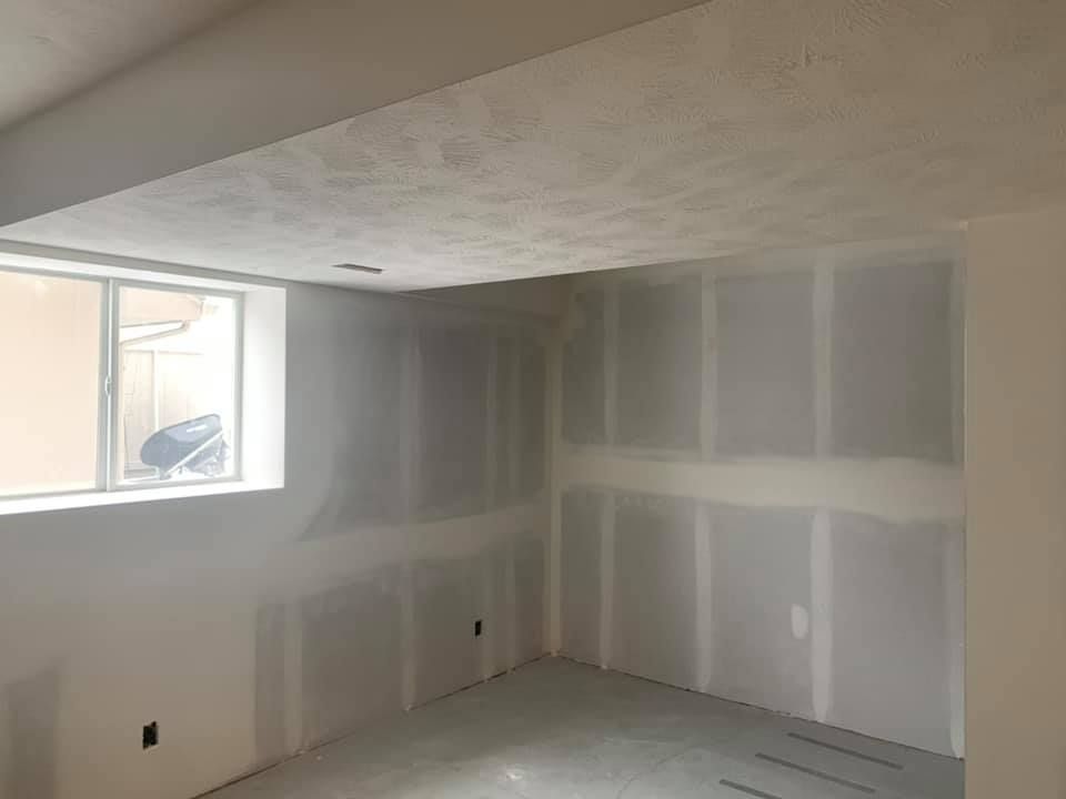 A room with a window and drywall on the walls.