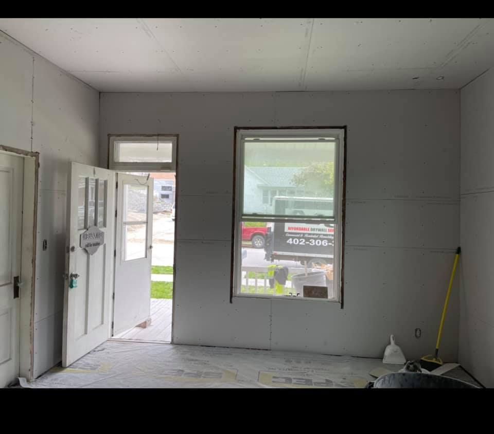 A room with a window and a door is being remodeled.