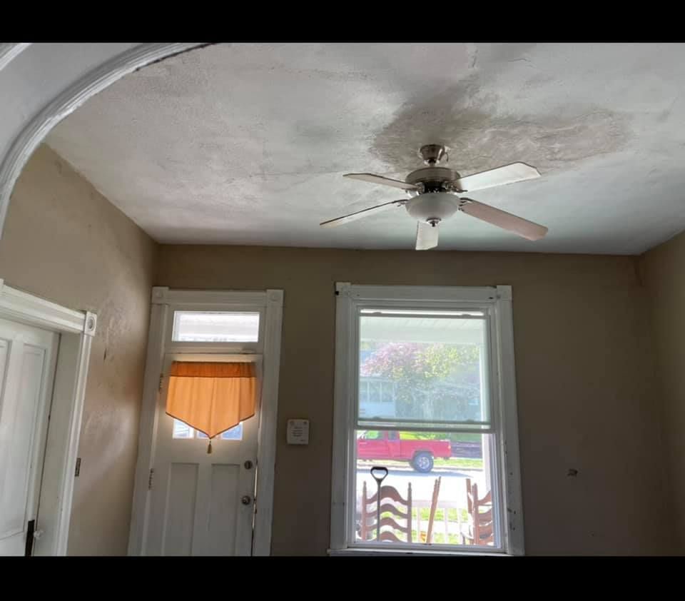 A room with a ceiling fan and a window