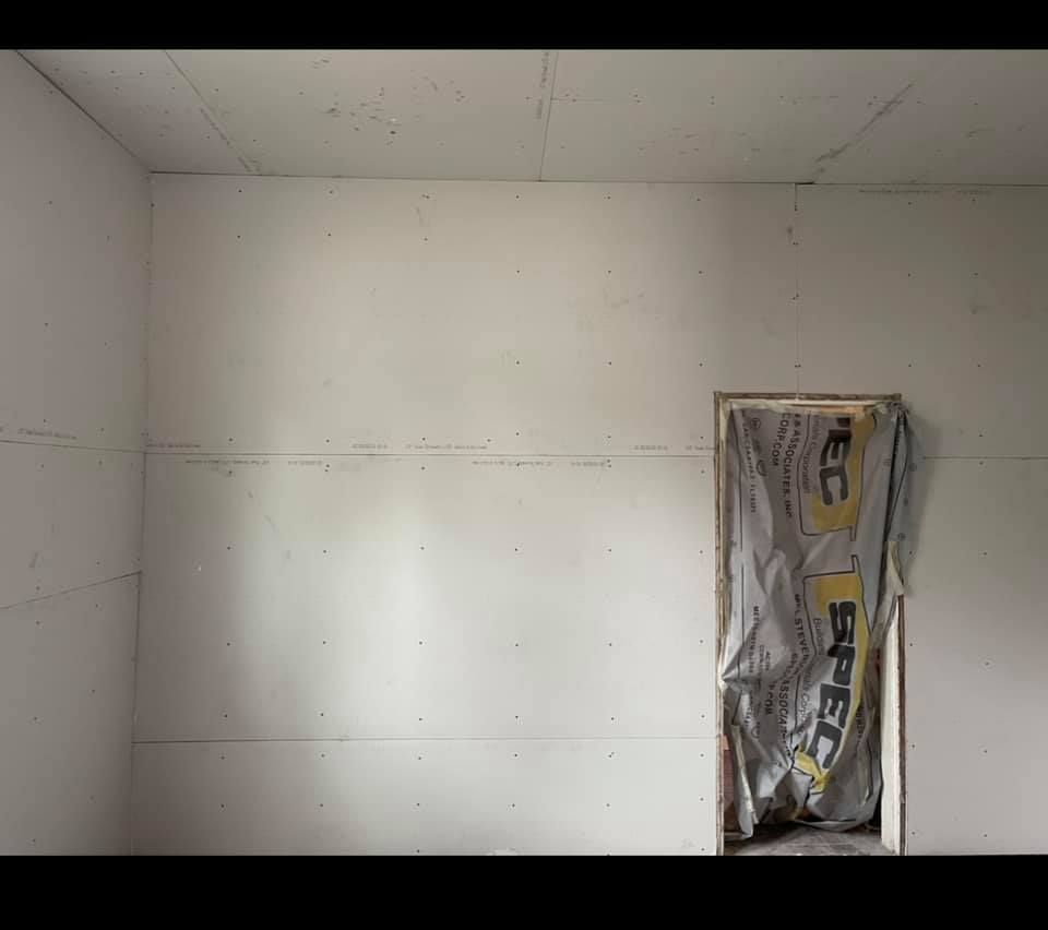 A room with white walls and a door in it.