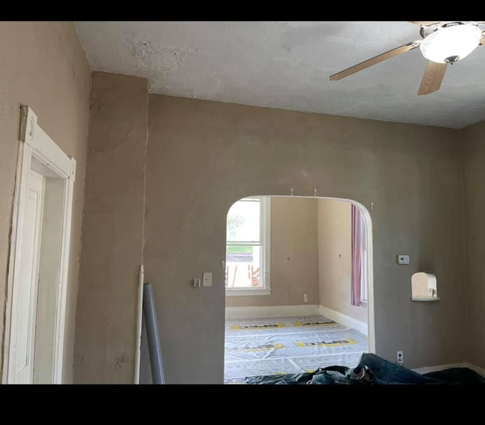 A living room with a ceiling fan and a window.