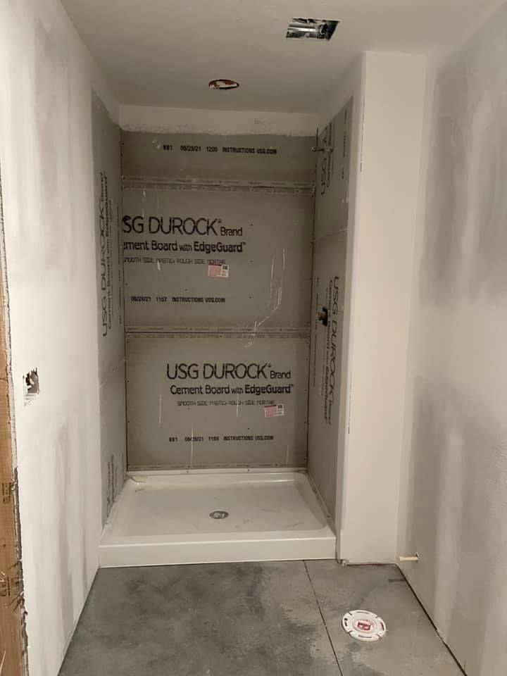 A bathroom under construction with a shower stall and a toilet.