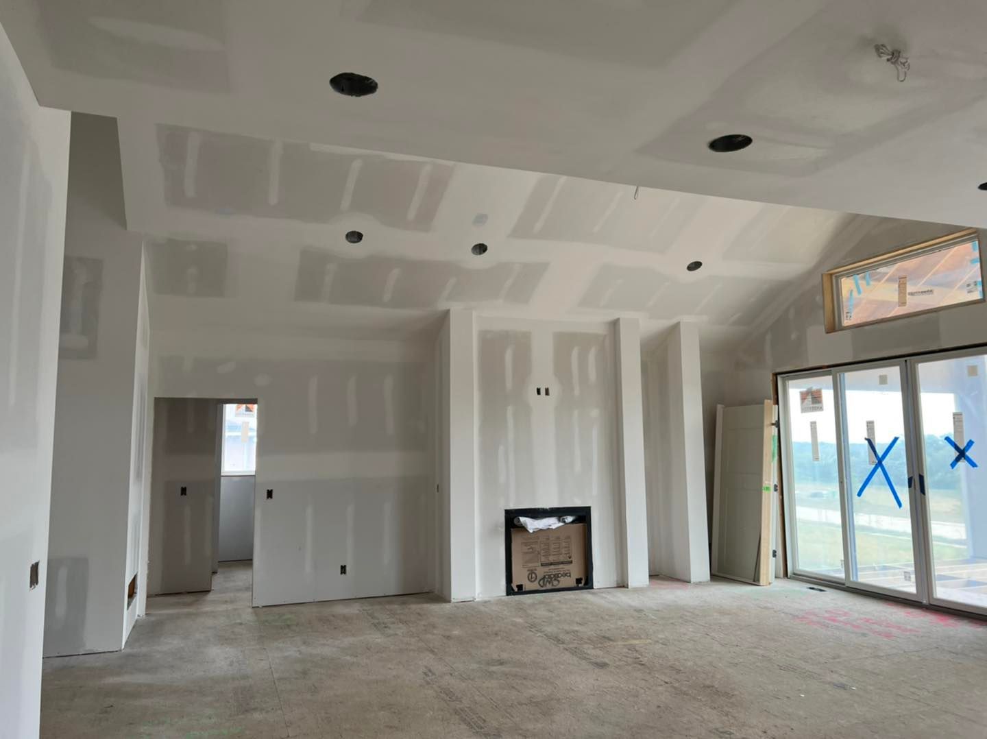 An empty room with a fireplace and sliding glass doors