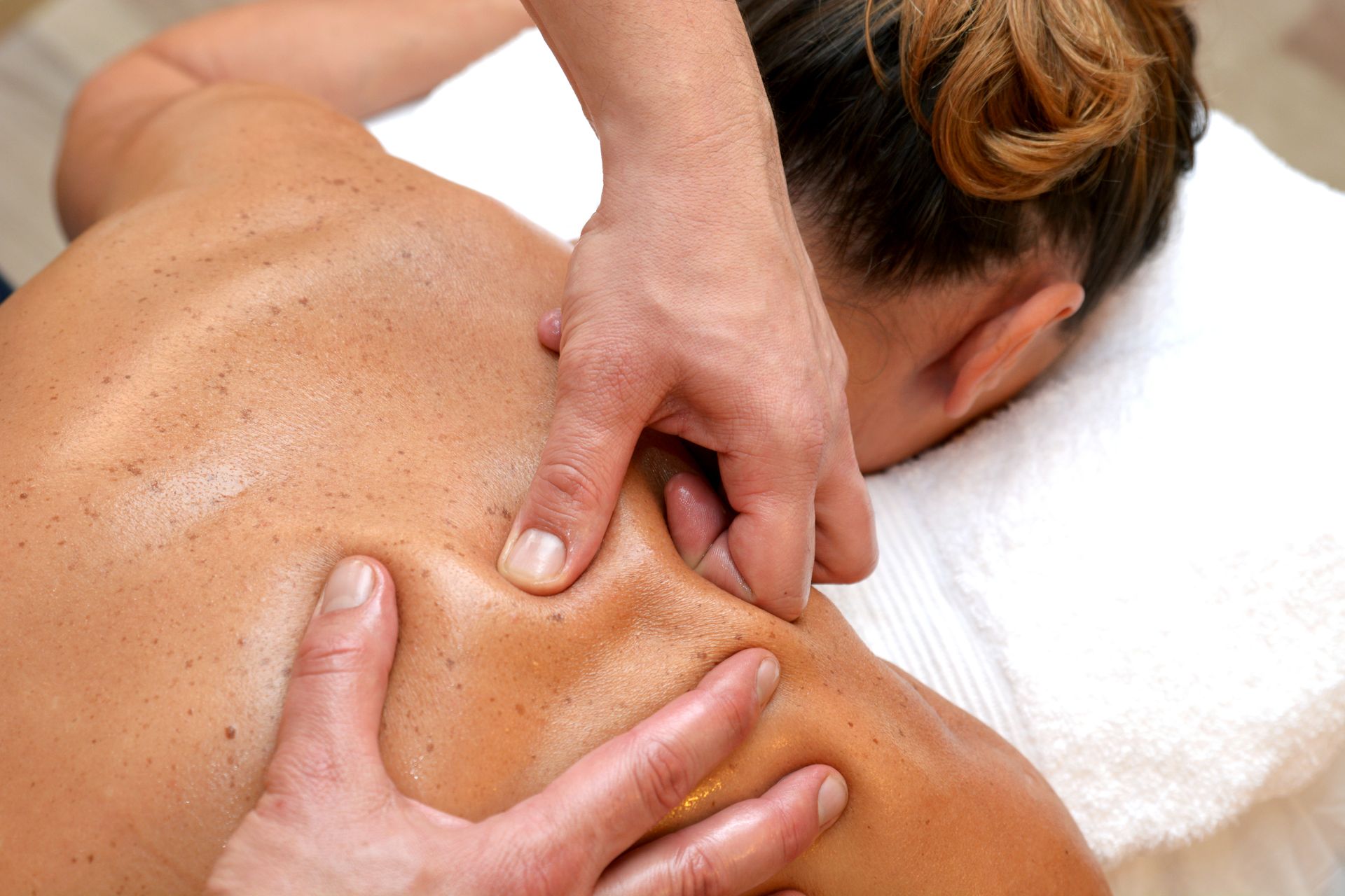 A woman is getting a massage on her back at a spa.