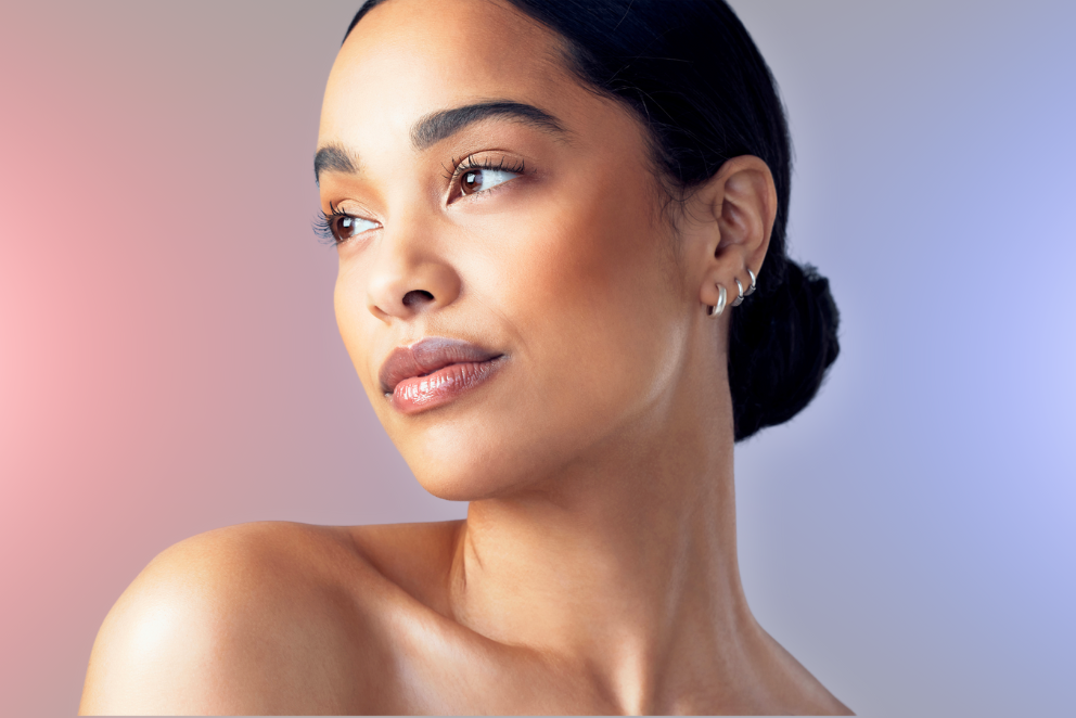 A close up of a woman 's face with a bun and earrings.