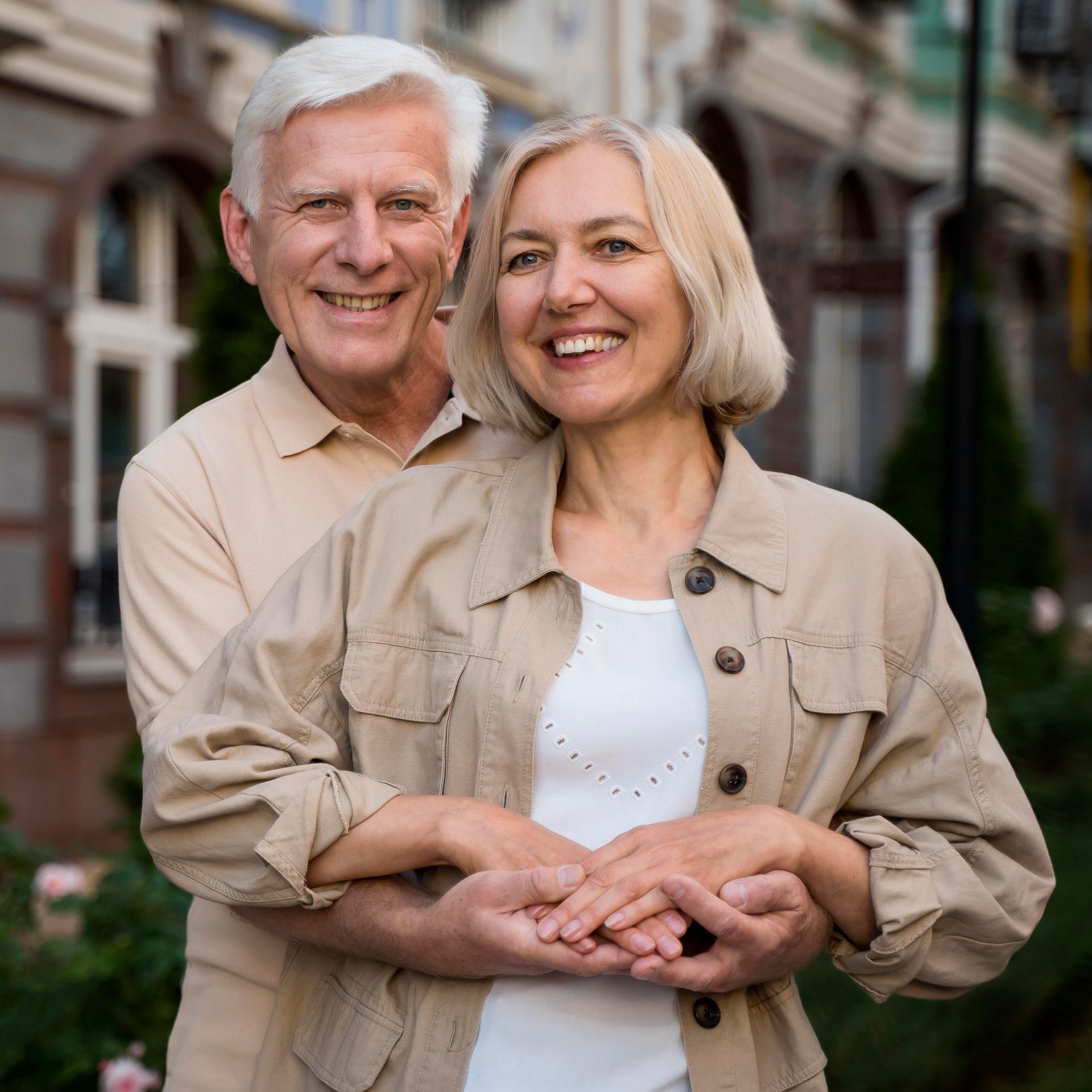 A man is hugging a woman in front of a building.