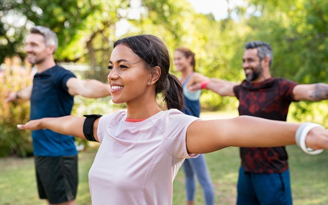 A group of people are doing yoga in a park.