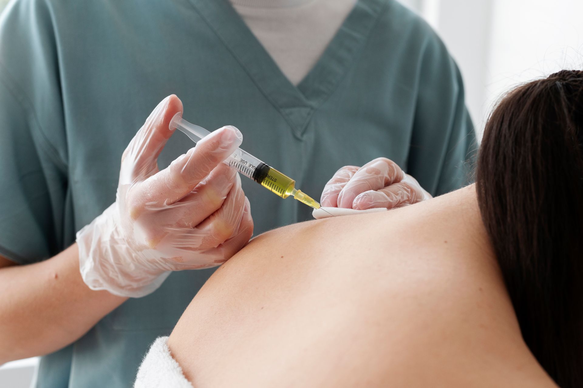 A woman is getting an injection in her back.