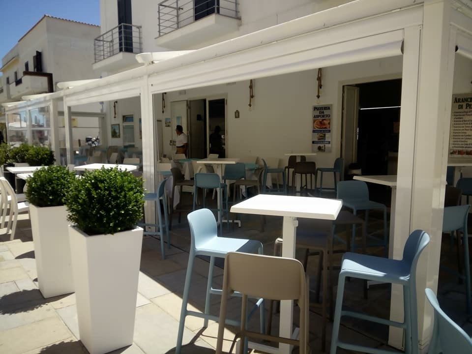 dehors di un locale con sgabelli e tavoli alti