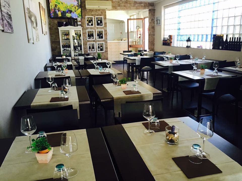 ristorante con tavoli neri e tovaglie beige