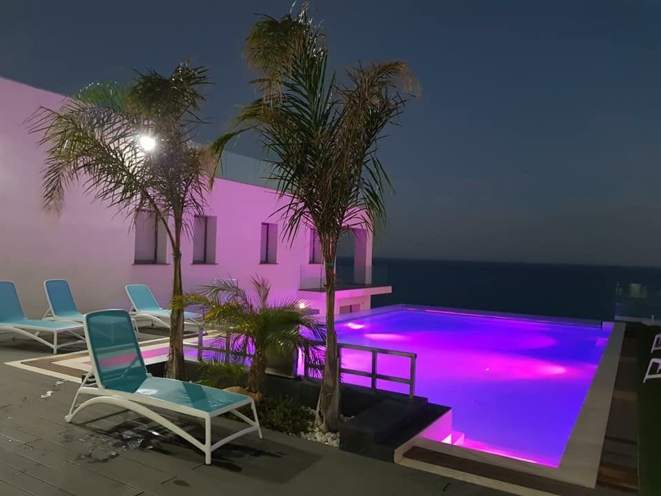 giardino con piscina e sdraio azzurre