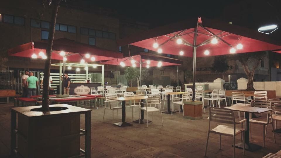 dehors di un ristorante con ombrelloni rossi