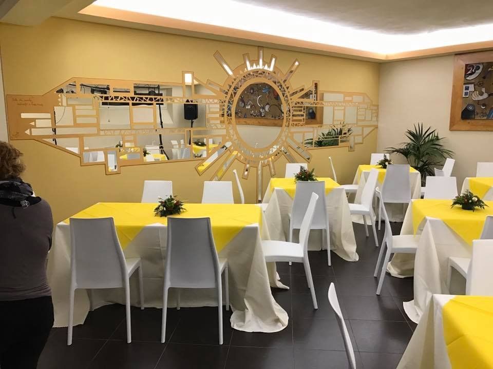 locale con sedie bianche e tavoli gialli