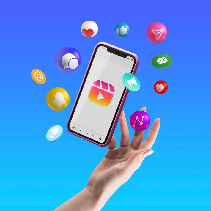 A hand is holding a cell phone with social media icons flying around it.