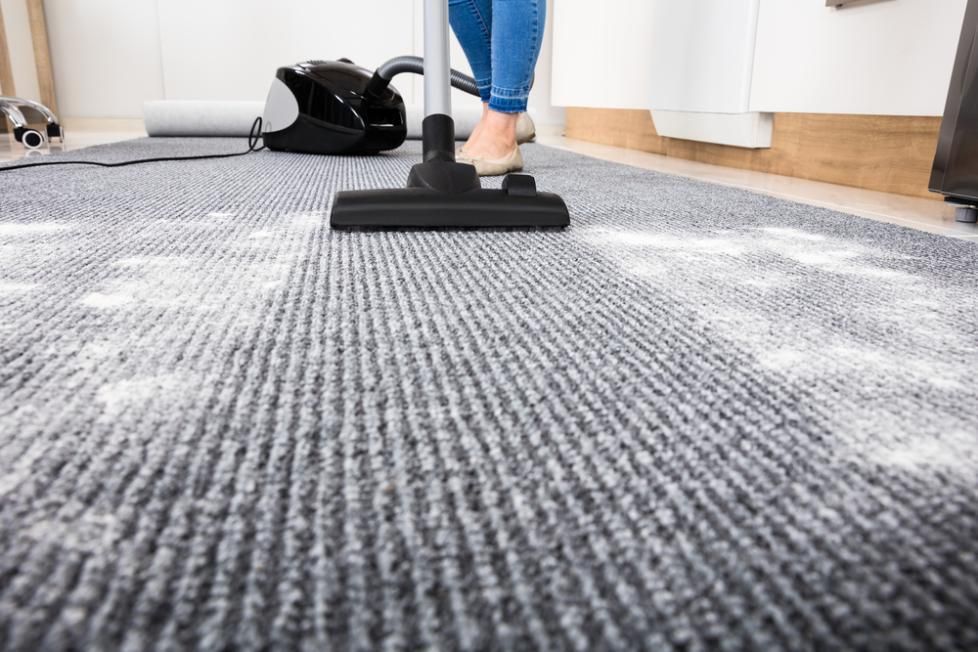 A Woman Is Using A Vacuum Cleaner To Clean A Carpet — Amy's Domestic Agency In Pimlico, QLD