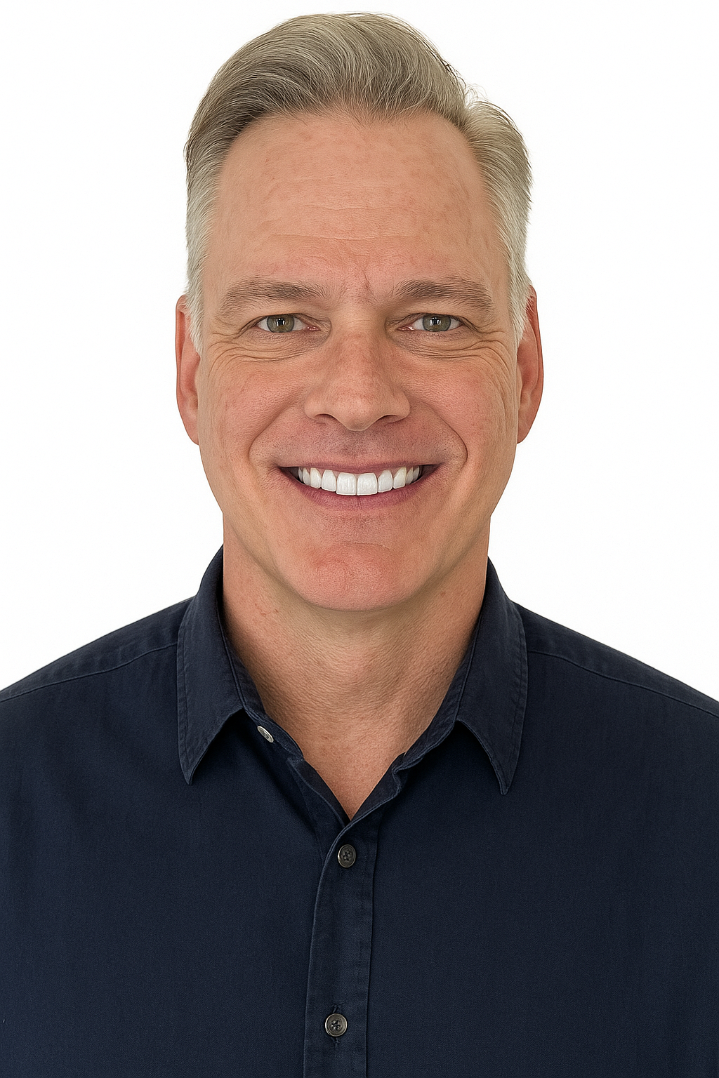 Man with graying hair smiles broadly, wearing a dark blue button-down shirt.