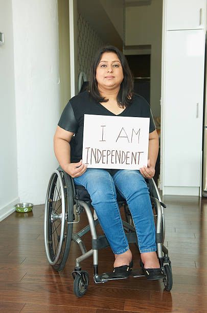 Woman in wheelchair holding a sign that reads 