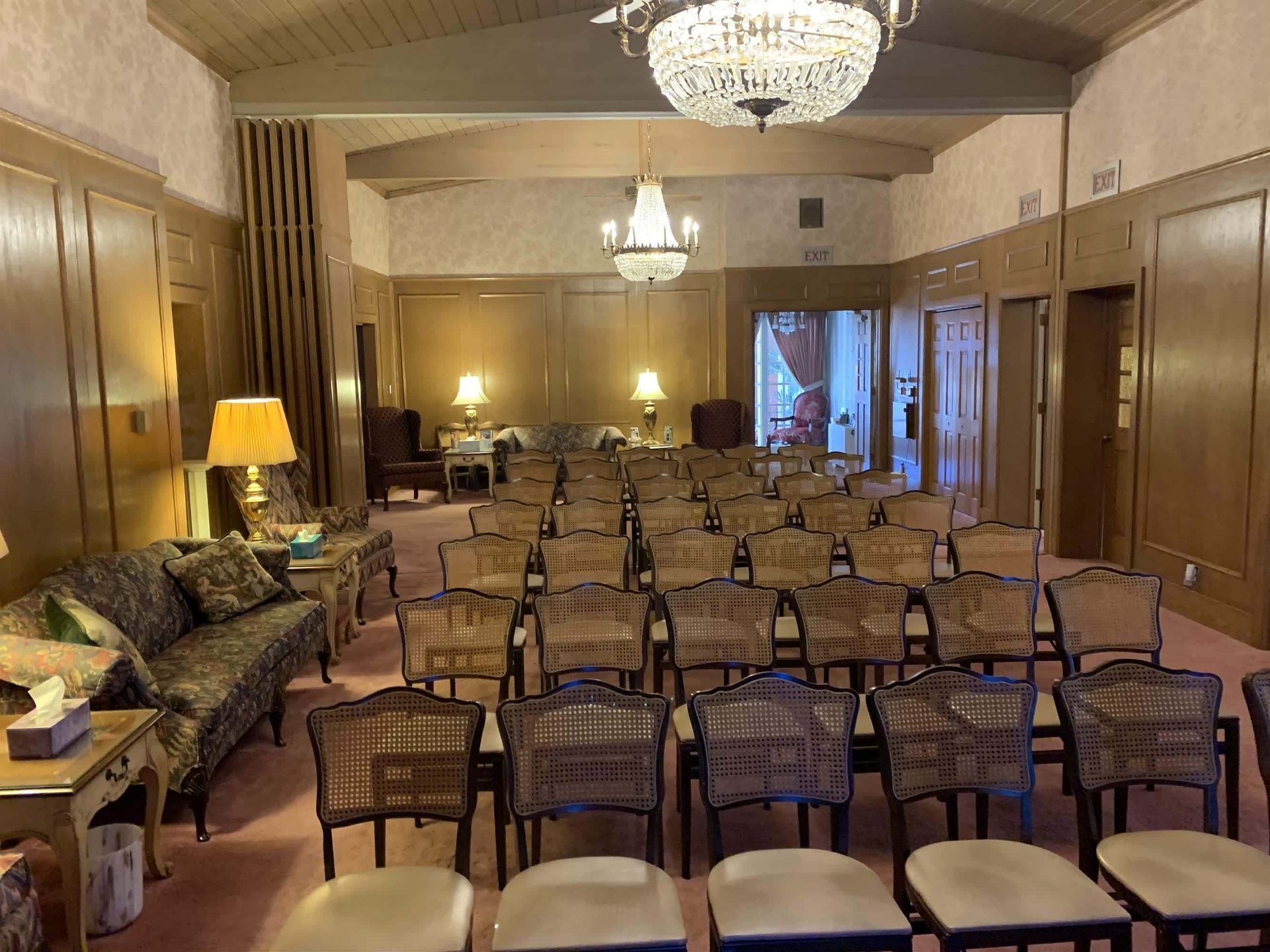 A large room with rows of chairs and a chandelier