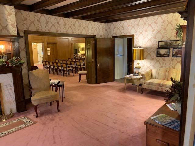 A living room with a pink carpet and chairs