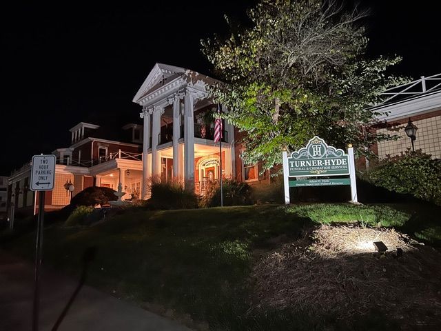 A large building with a sign in front of it at night.