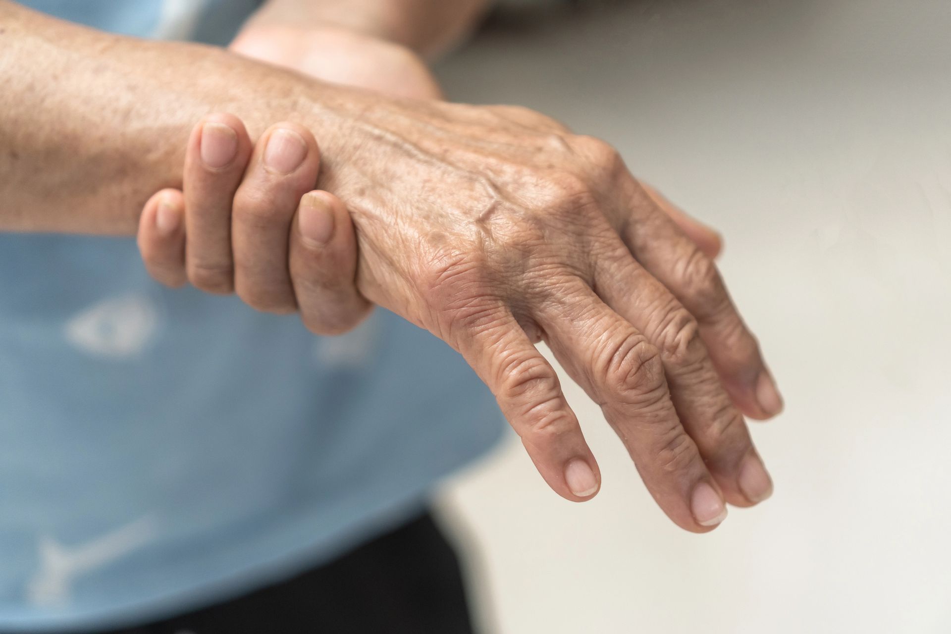 Person holding a wrist with a visibly bent hand, suggesting pain or injury