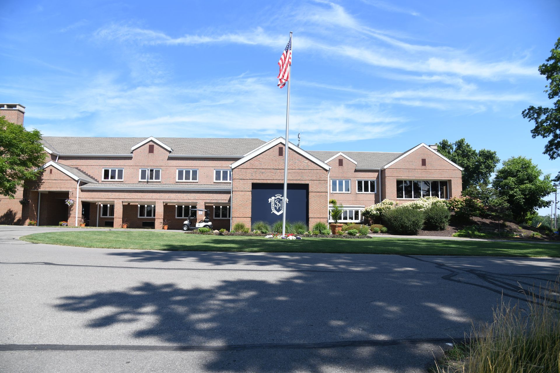 Brick building with a flagpole and American flag on a sunny day.
