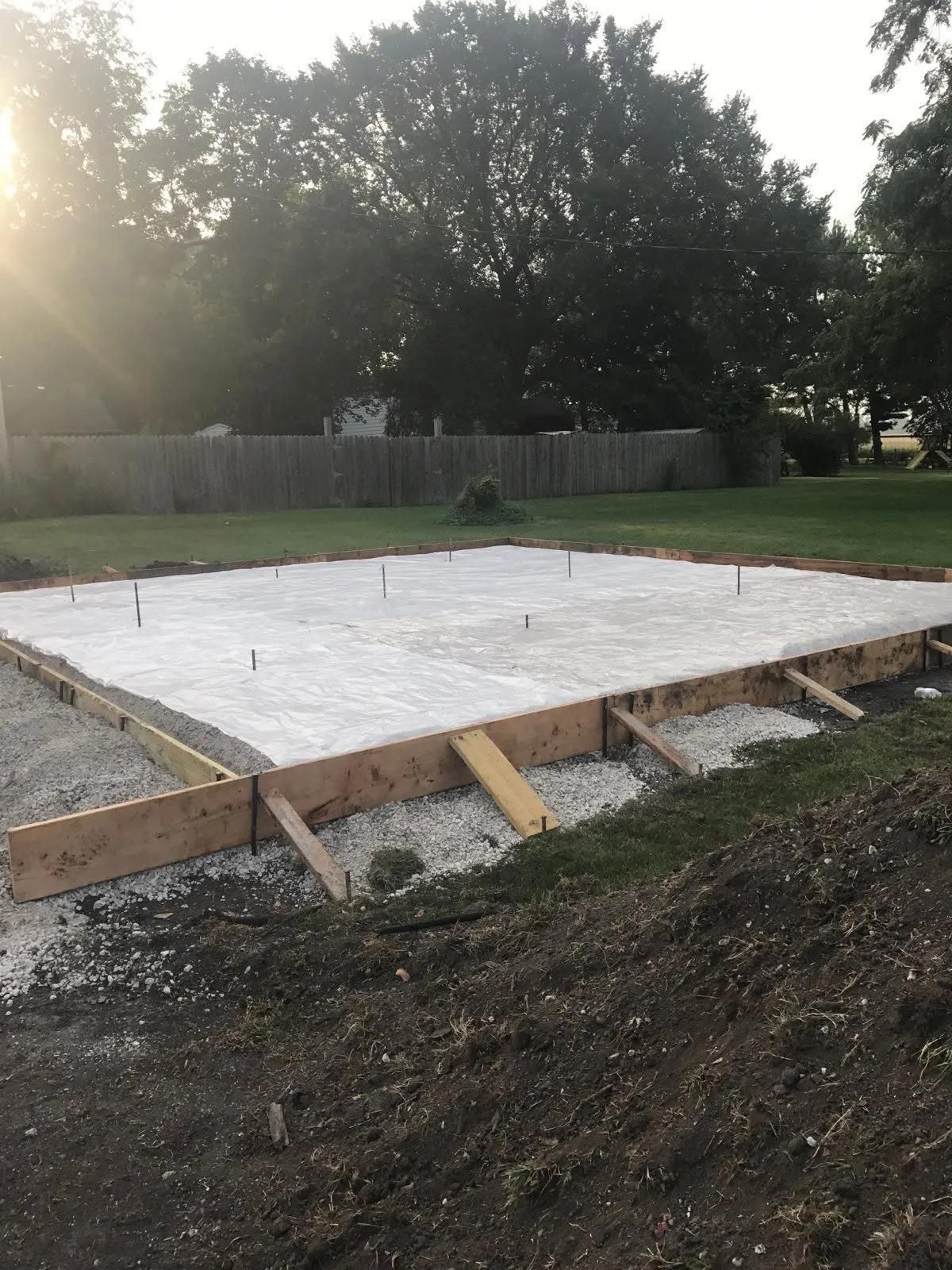 A concrete foundation is being built in a backyard.