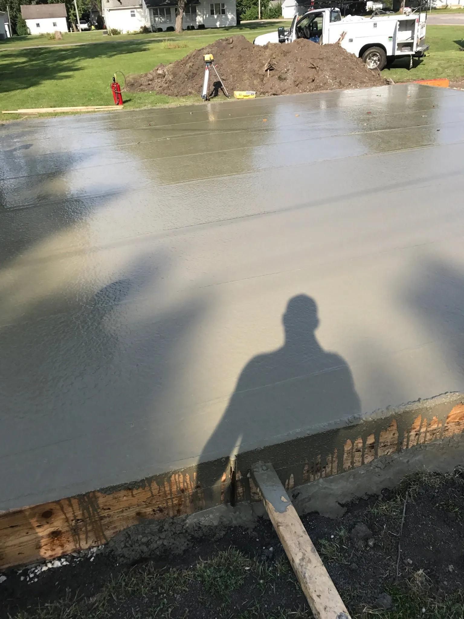 A shadow of a man is cast on a concrete surface.