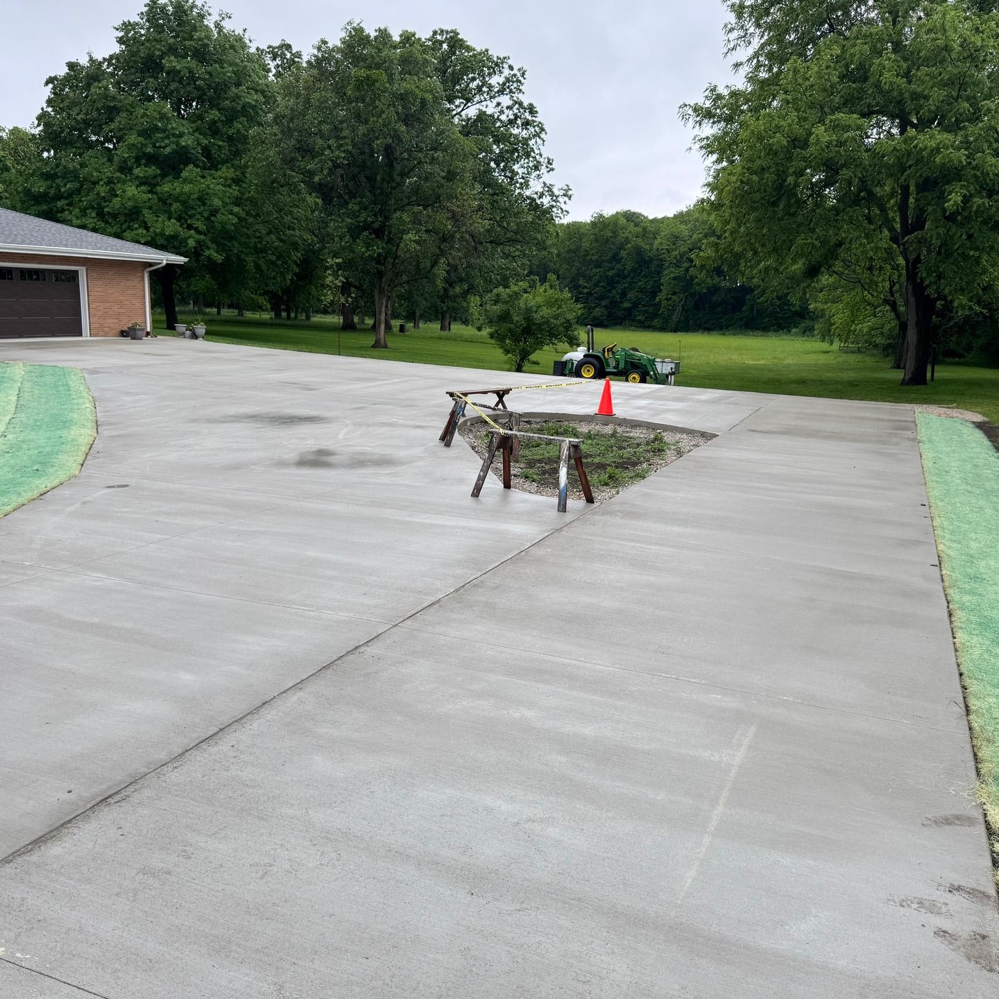 A concrete driveway with a fire pit in the middle