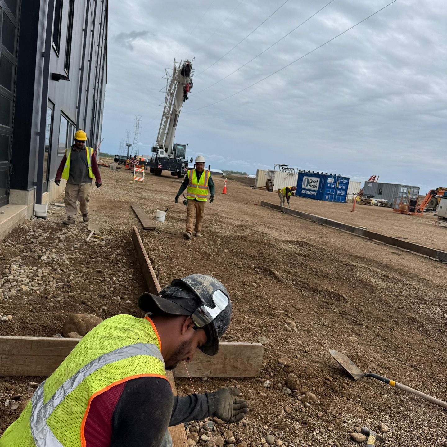 A man wearing a hard hat is working on a construction site