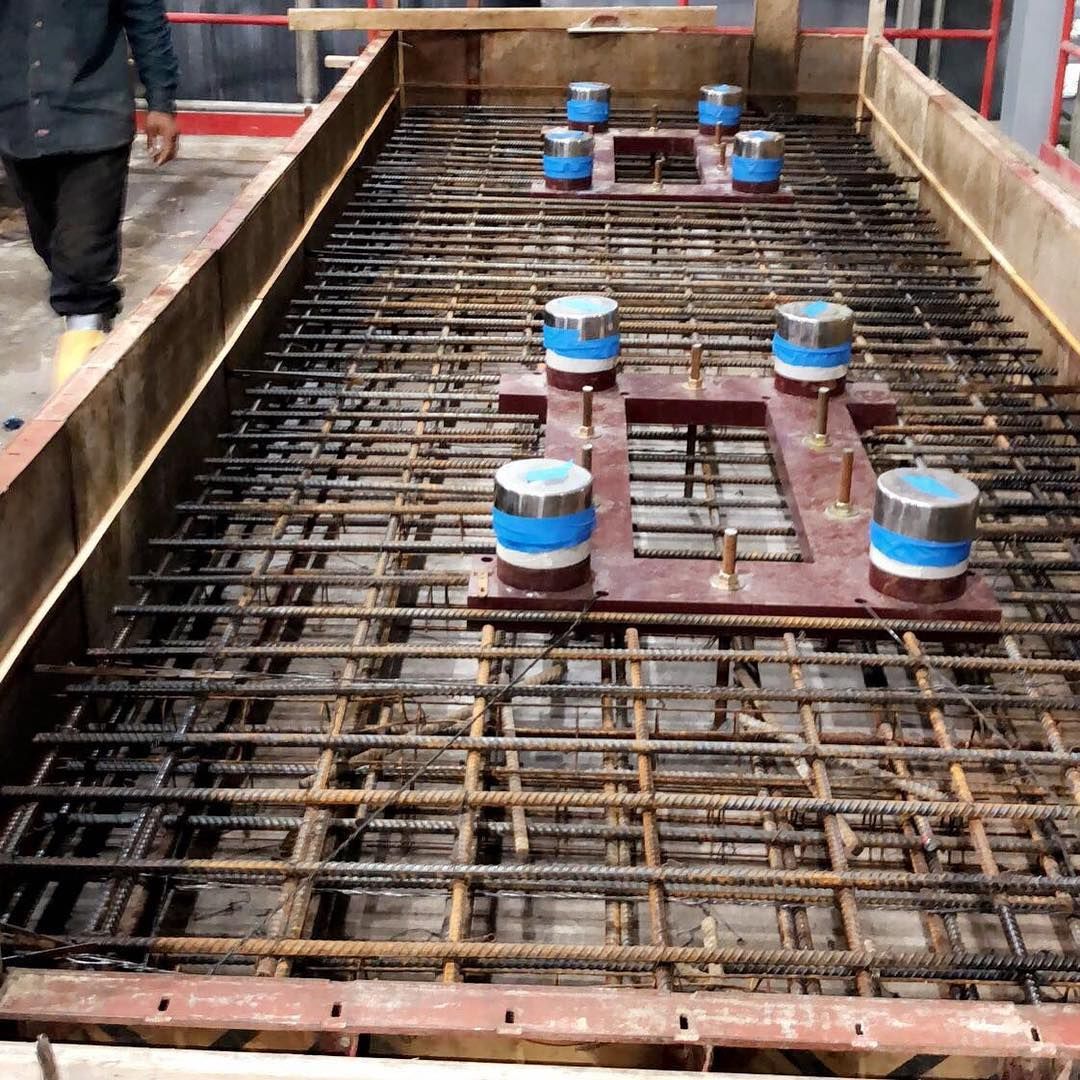 A man is walking across a large metal grid