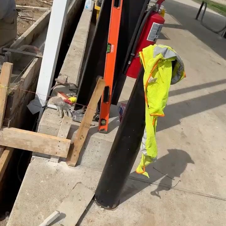 A yellow jacket is hanging on a pole next to a fire extinguisher