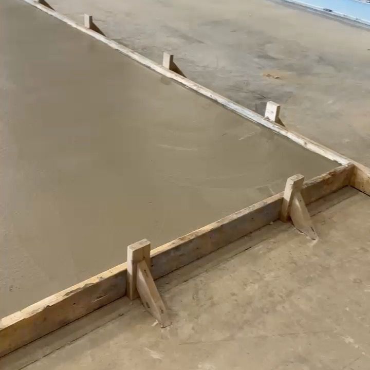 A close up of a concrete floor with a wooden frame.