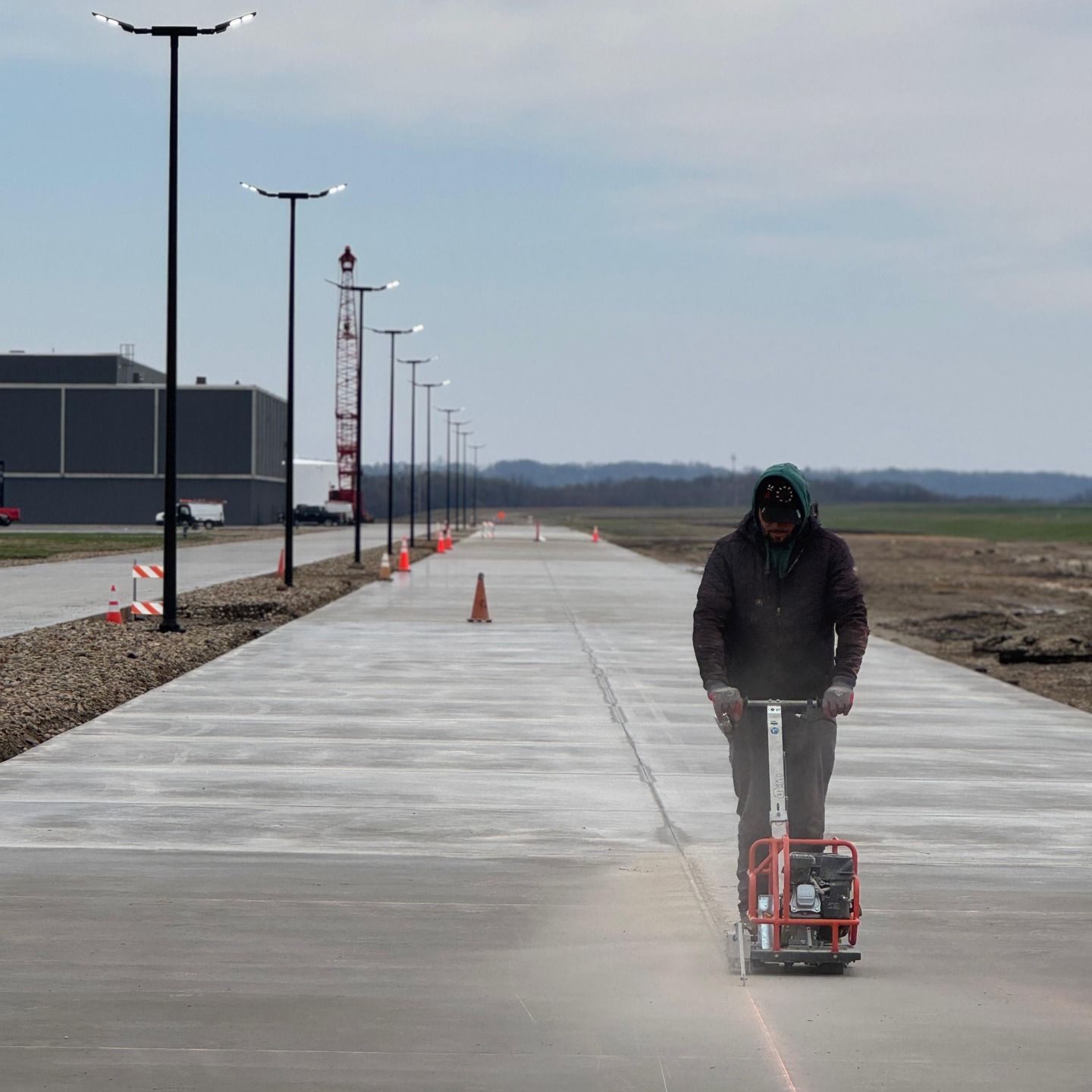 A man is riding a scooter down a concrete road