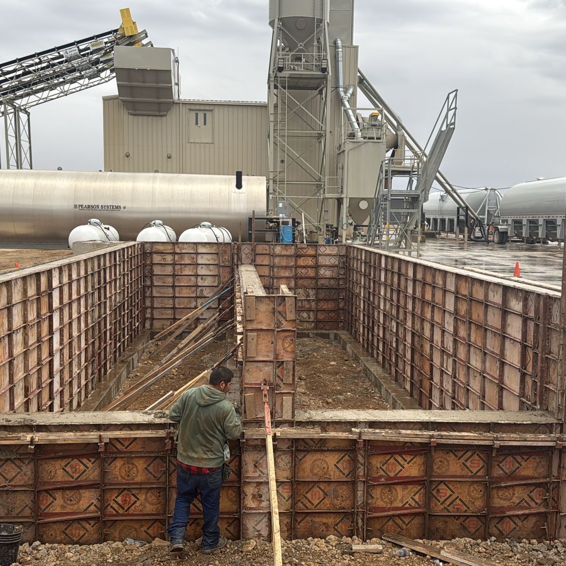 A man with a shovel is working on a concrete wall