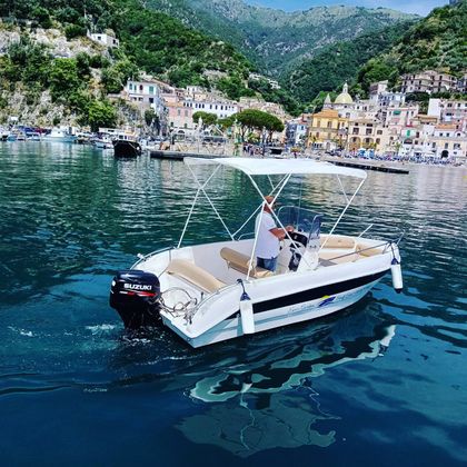 A boat with a canopy is floating on top of a body of water.